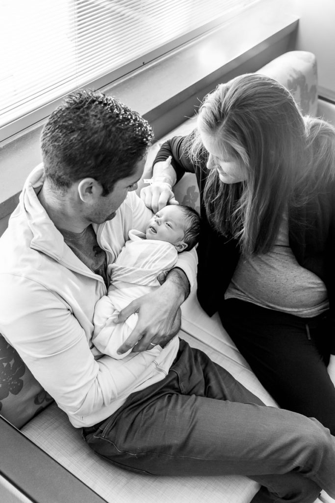 parents sit together with newborn son