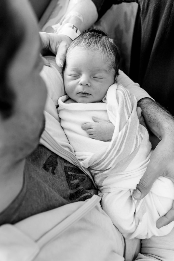 black and white image of new parents with baby son