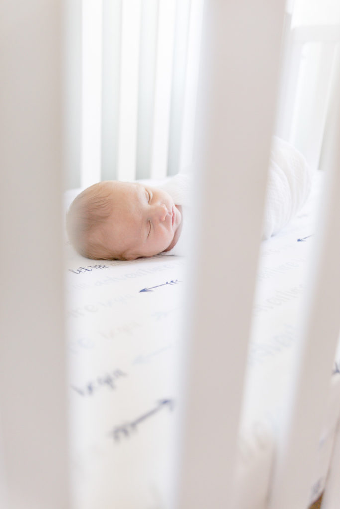 newborn boy in white crib