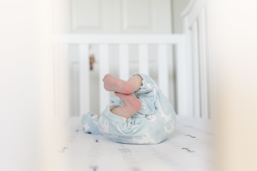 newborn feet in white crib