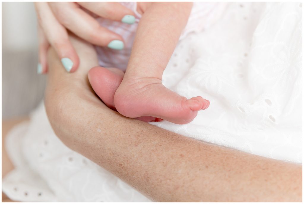 tiny pink newborn foot captured during mommy snuggles