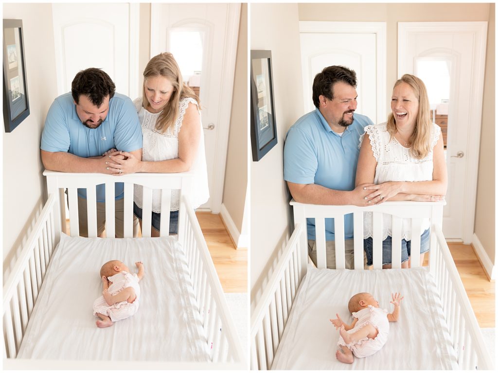 mom and dad laugh over baby in crib