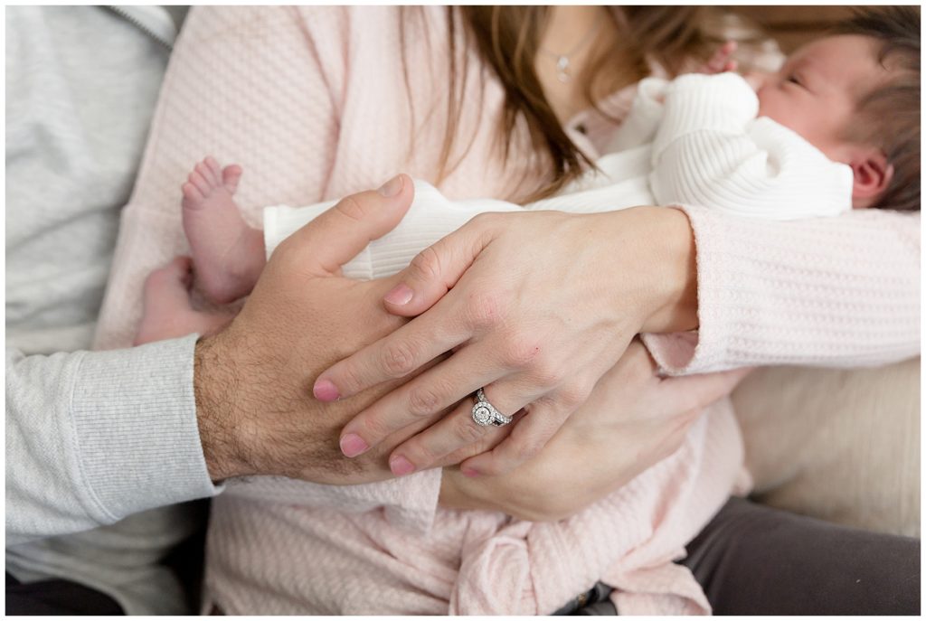mom and dad's hands cradling newborn