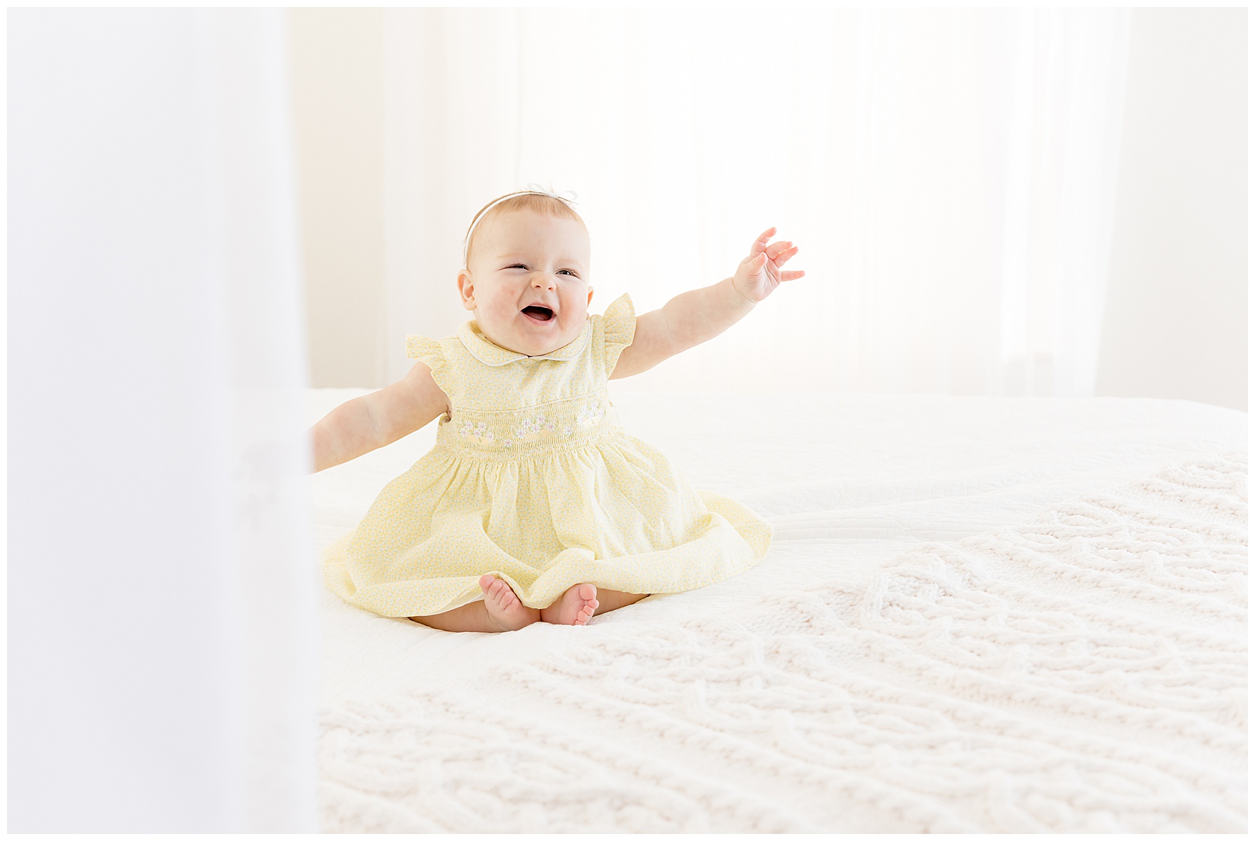 baby in yellow dress on white bed