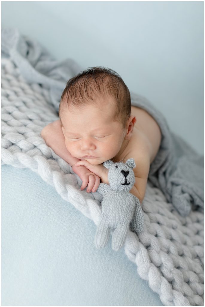 baby on blue with lovey in hand
