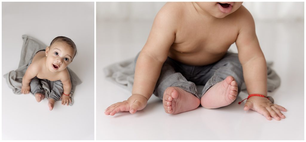 baby in gray pants in white photo studio space