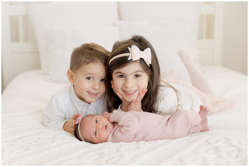big sister and brother with newborn sister
