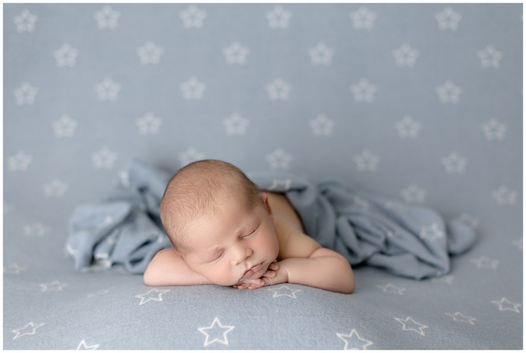 sleepy newborn boy on blue, starred fabric