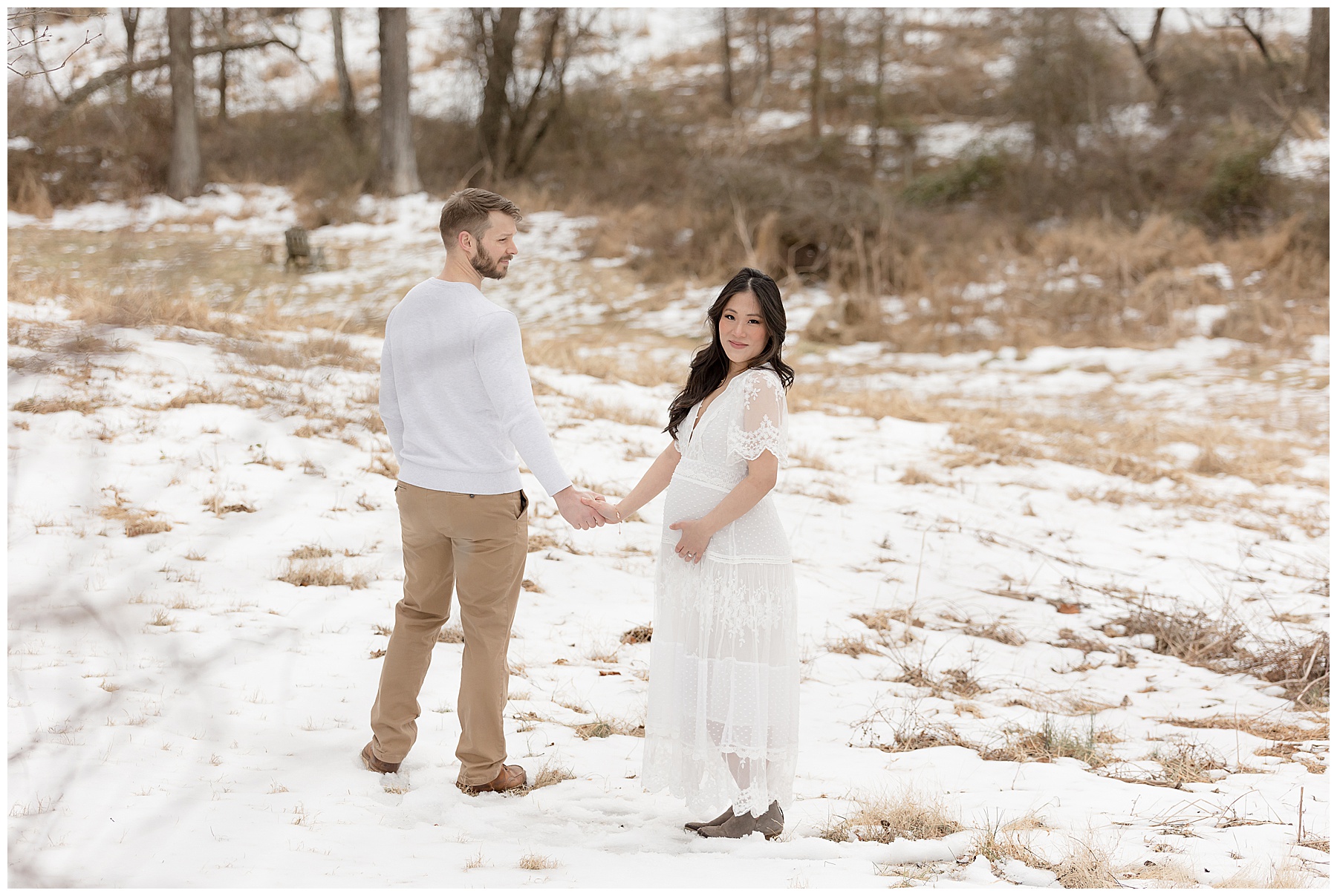 man looks at pregnant wife during Winter Maternity Photos at the Howard County Conservancy