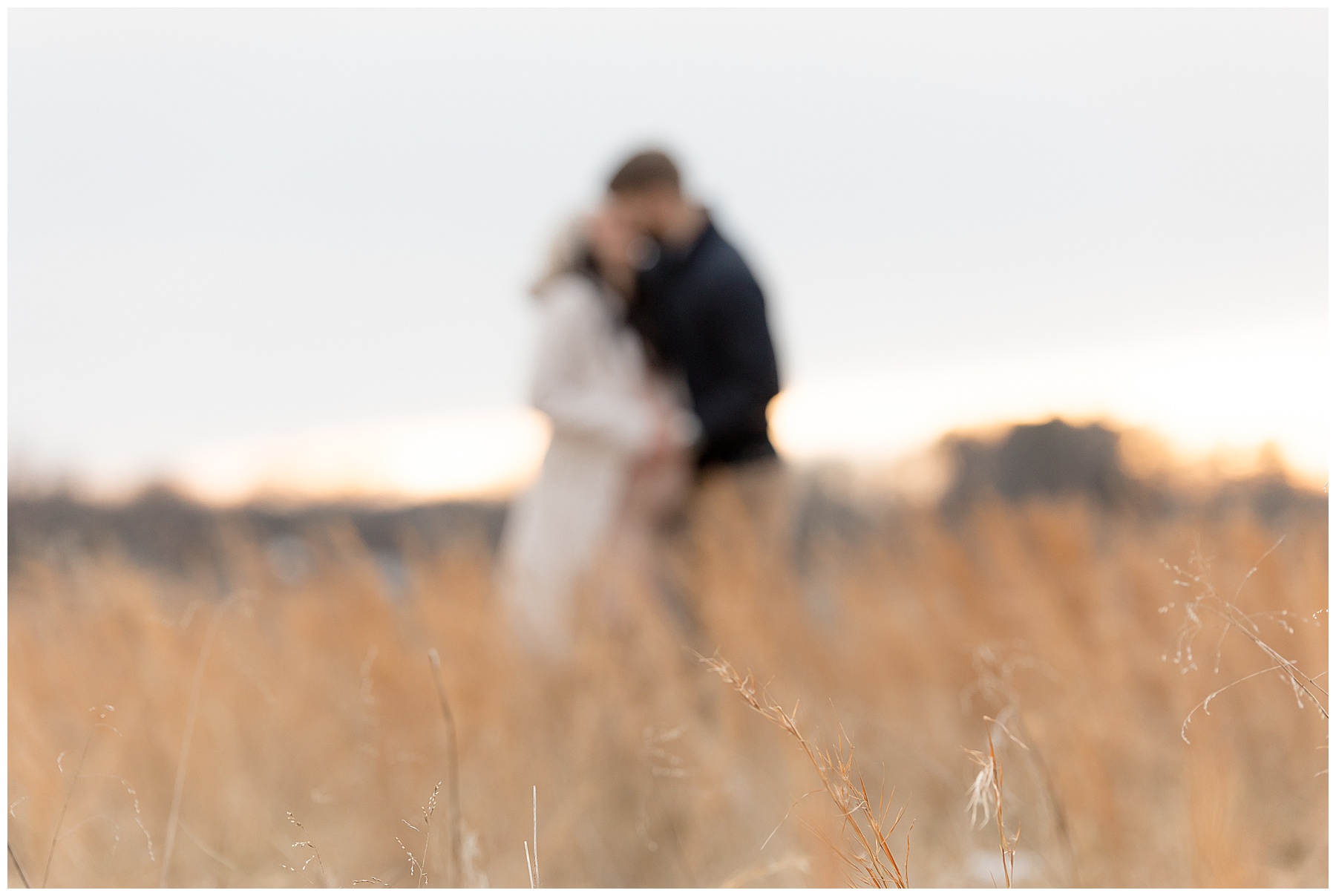 couple fades into the setting sun surrounded by golden grasses