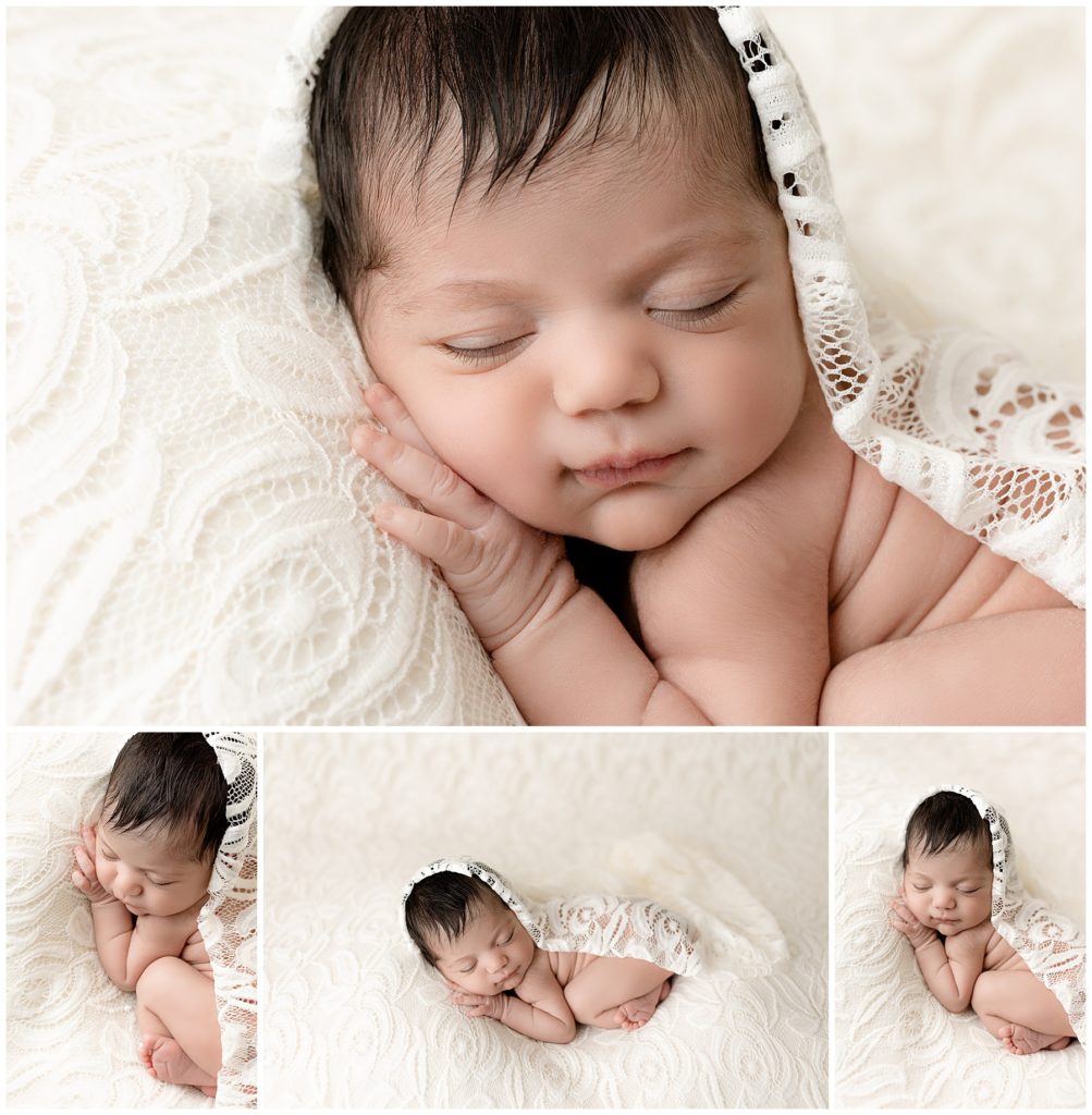newborn girl on white lace backdrop