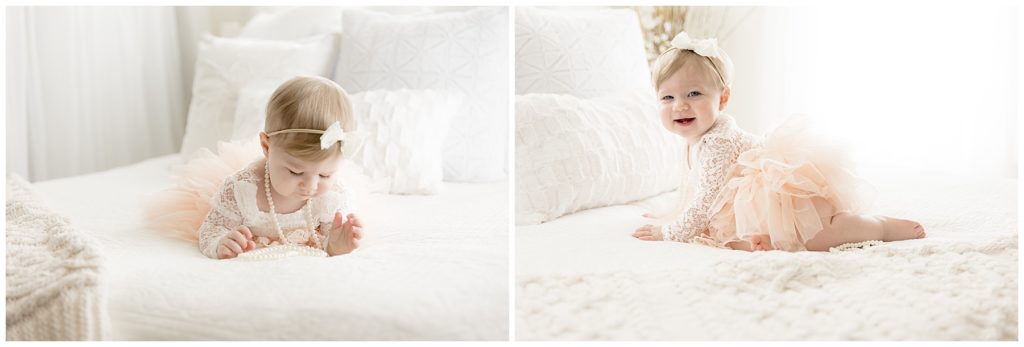 baby giggles and examines pearls during one year photos