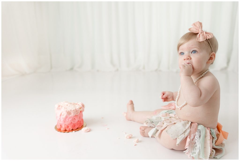 toddler girl smashes cake in first birthday pictures