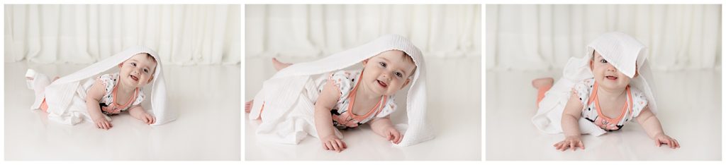 baby plays with white blanket, watching baby grow, pictures