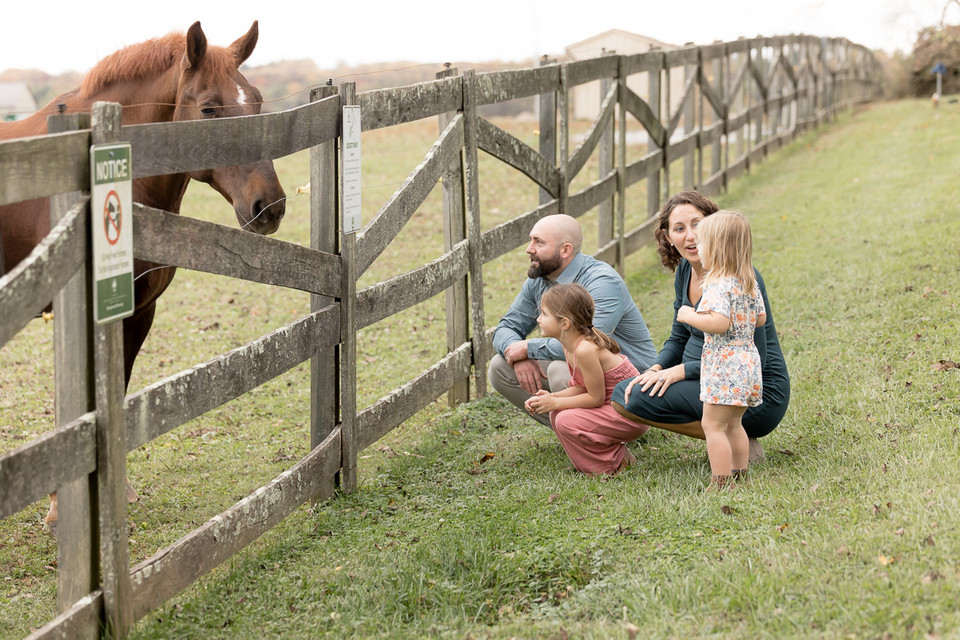 family takes time to visit with horses