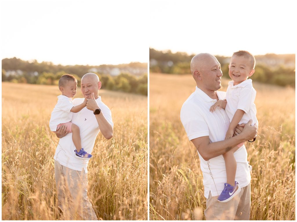 dad snuggles young son in field