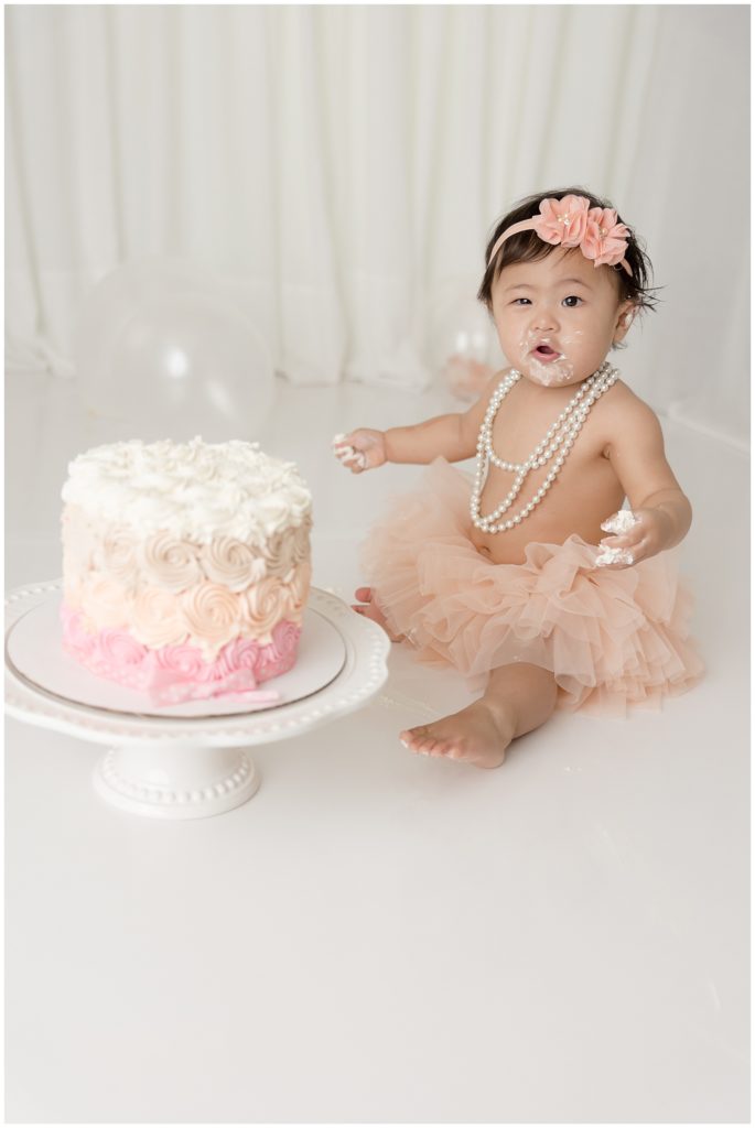 baby makes face at birthday cake