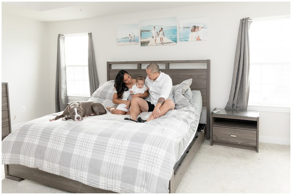 family with dog takes picture on master bed