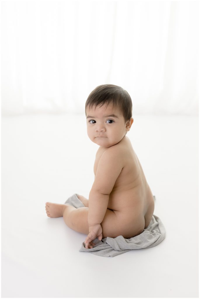 baby looking over shoulder in white room
