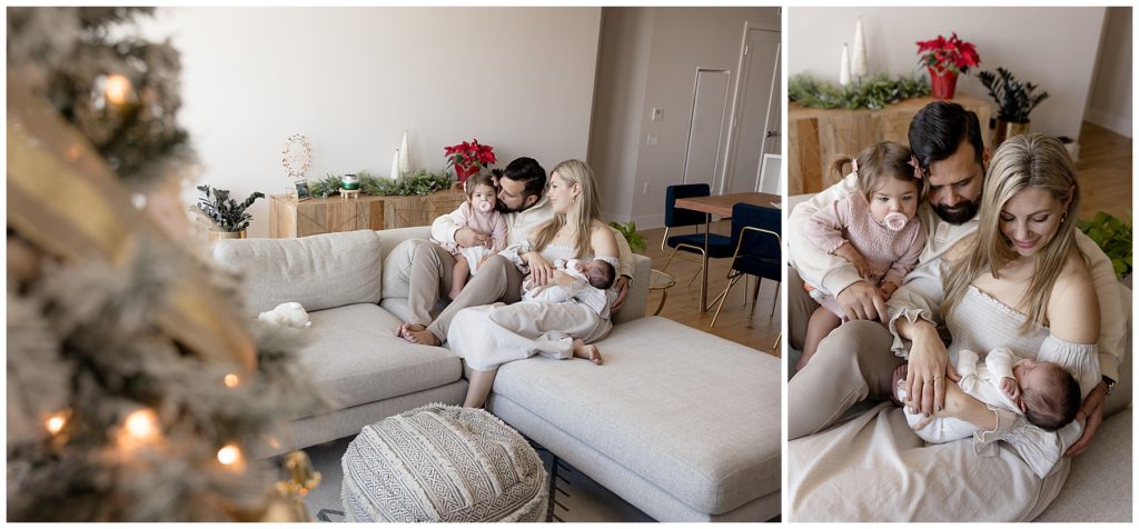 family snuggles with new baby in living room decorated for Christmas
