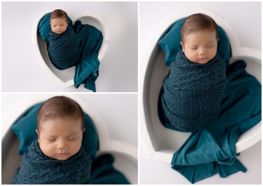 newborn boy wrapped in teal posed in white heart bowl
