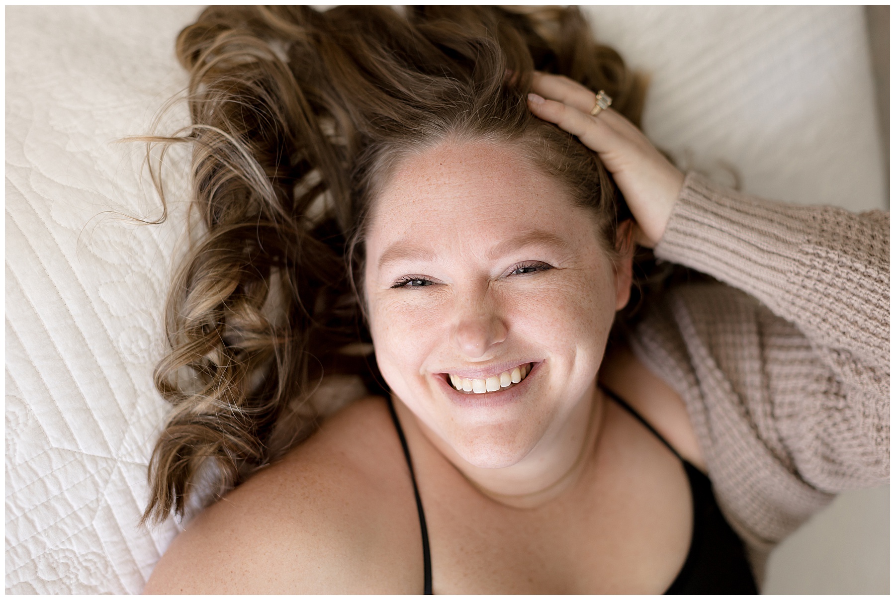 Body Love Photography - smiling woman lays on her back on the bed