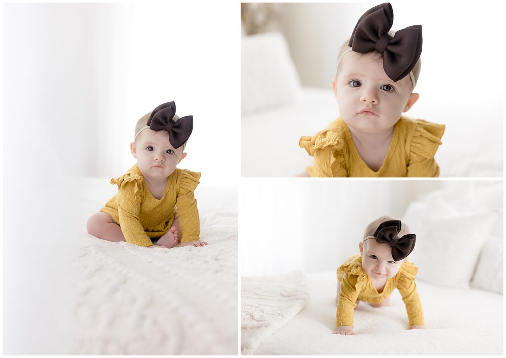 Sweet baby girl in yellow dress and big brown headband sits on my white studio bed