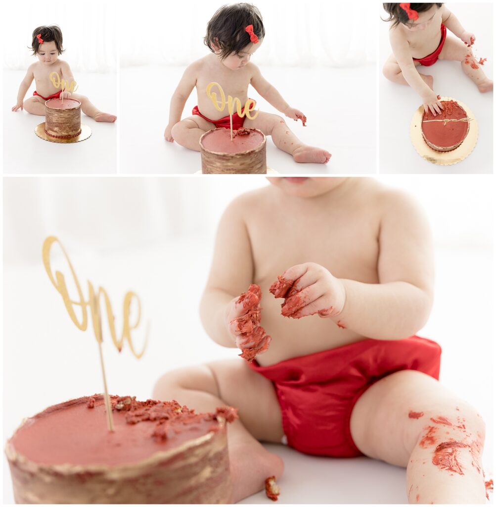 Baby in red bloomers gets messy with her smash cake during her cake smash photography session