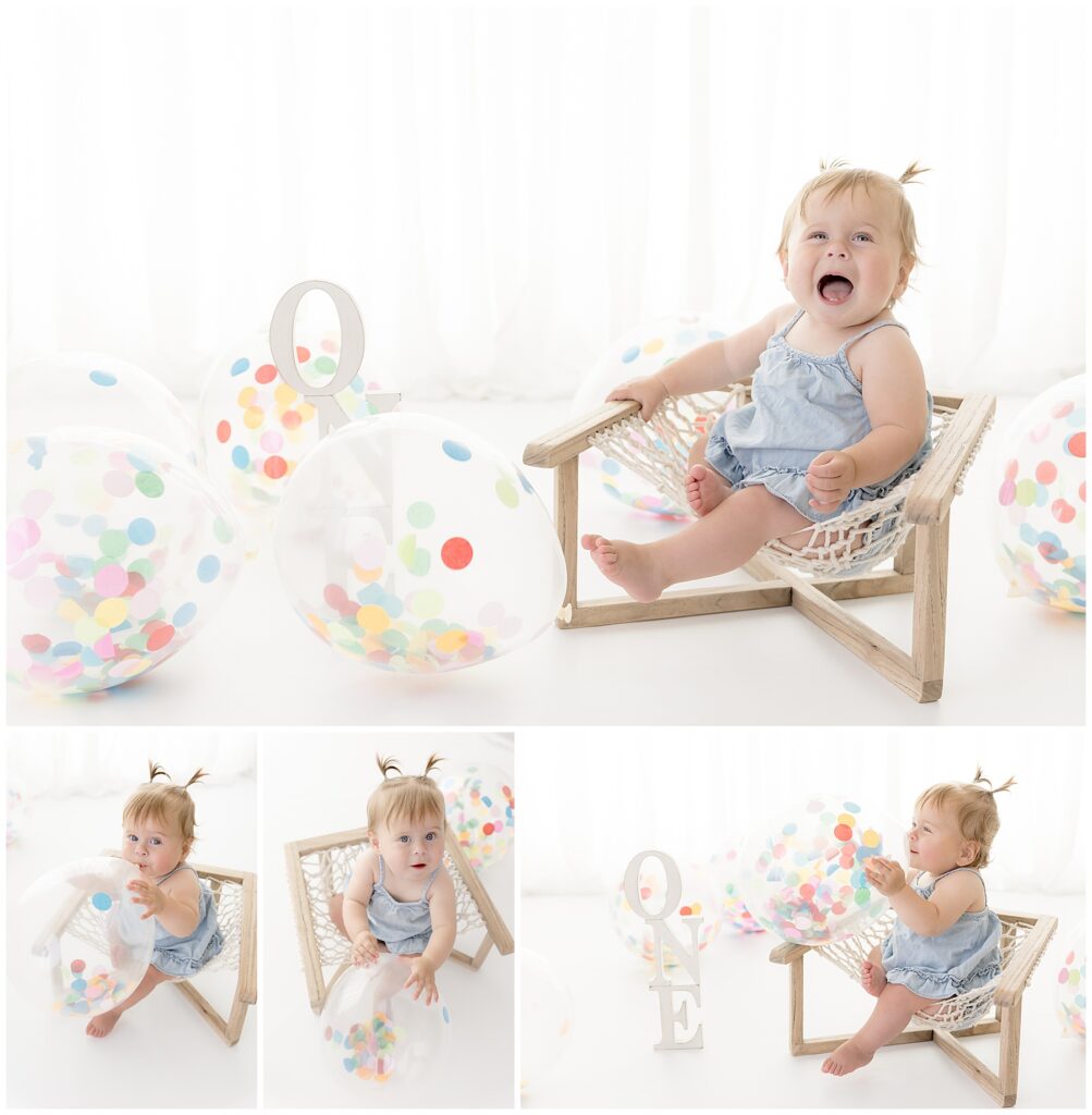 baby sits in hammock chair surrounded by confetti balloons and letters spelling out ONE