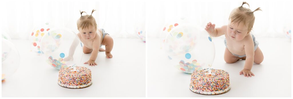baby crawls toward her birthday cake with curiosity