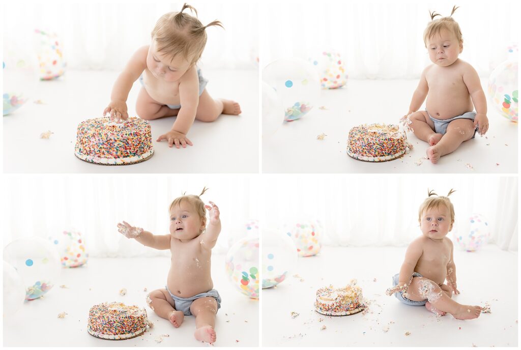 messy baby experiences the feeling of cake and icing on her fingers and isn't sure what she thinks about the experience
