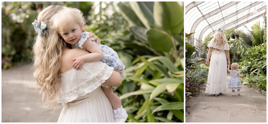 mom hugs toddler and walks with her during greenhouse pregnancy announcement photos