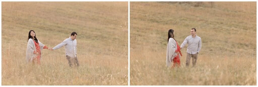 pregnant couple walks in tall field during their session for pregnancy photos 