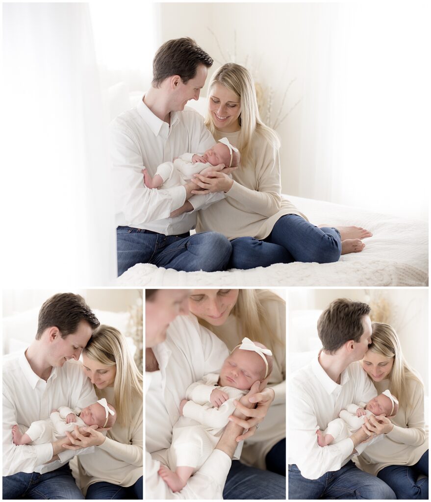 parents pose with newborn baby girl on white studio bed in newborn baby photoshoot