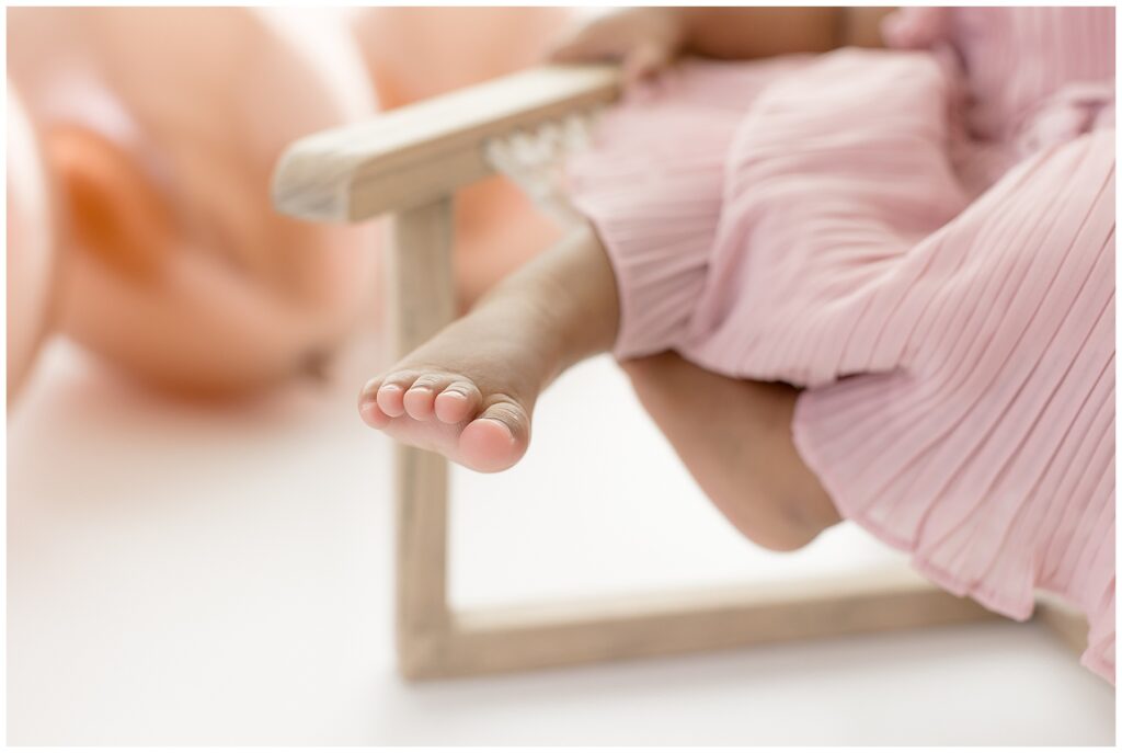 close up shot of little girl's toes and her pretty pink dress